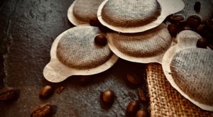 Kaffeepads und Kaffeebohnen auf dem Tisch 