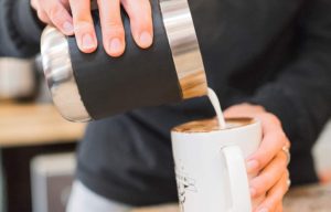 Milchschaum flie?t aus dem Pitcher 